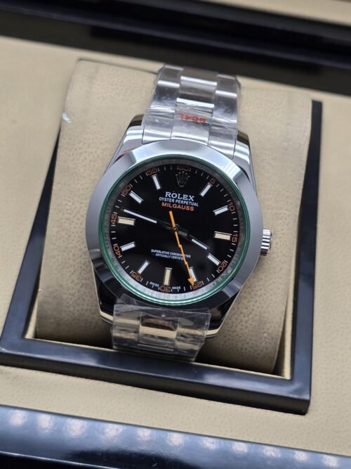 Rolex — esfera negra con aguja naranja, aro verde y brazalete plateado