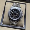 Rolex — esfera negra con tres subesferas claras, bisel y brazalete plateados