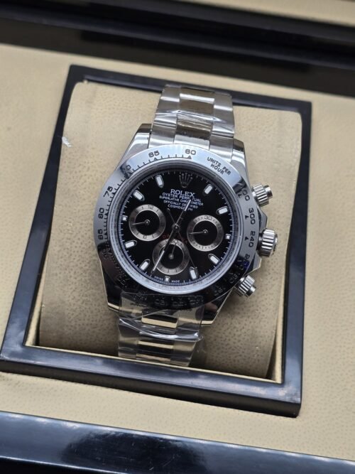 Rolex — esfera negra con tres subesferas claras, bisel y brazalete plateados