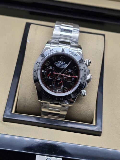Rolex — esfera negra con detalles rojos, tres subesferas y brazalete plateado