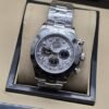 Rolex — esfera gris con patrón, tres subesferas y brazalete plateado