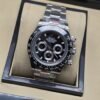 Rolex — esfera negra con tres subesferas, bisel negro y brazalete plateado