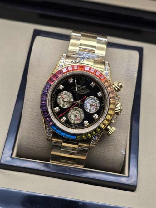 Rolex — esfera negra con subesferas doradas, bisel multicolor y brazalete dorado