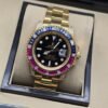 Rolex — esfera negra y bisel multicolor con brazalete dorado