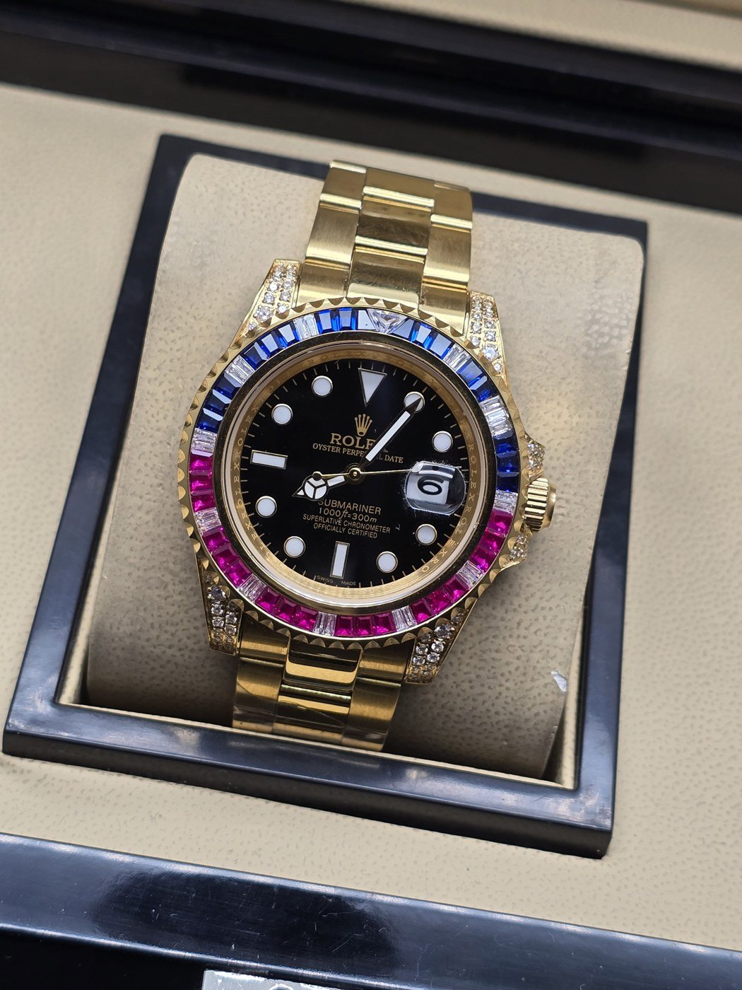 Rolex — esfera negra y bisel multicolor con brazalete dorado