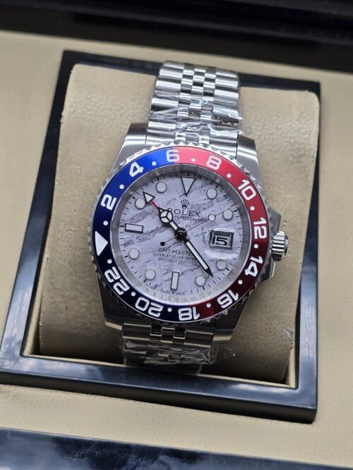 Rolex — esfera gris con patrón y bisel rojo y azul