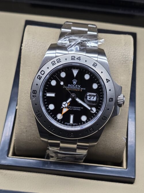 Rolex — esfera negra con bisel numerado plateado y aguja naranja