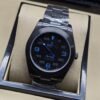 Rolex — esfera negra con números azules y caja negra