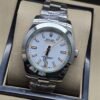 Rolex — esfera blanca con aguja naranja y brazalete plateado