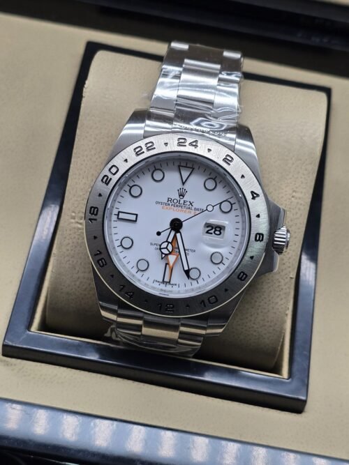 Rolex — esfera blanca con aguja naranja y bisel numerado plateado