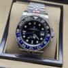 Rolex — esfera negra con bisel azul y negro, brazalete plateado