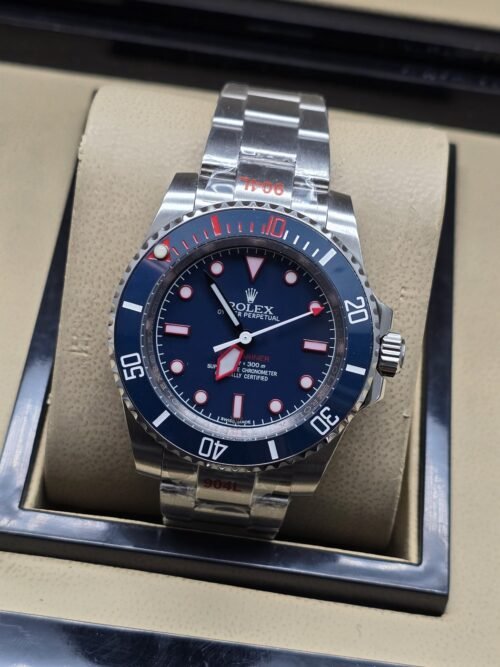 Rolex — esfera azul oscura con detalles rojos y brazalete plateado