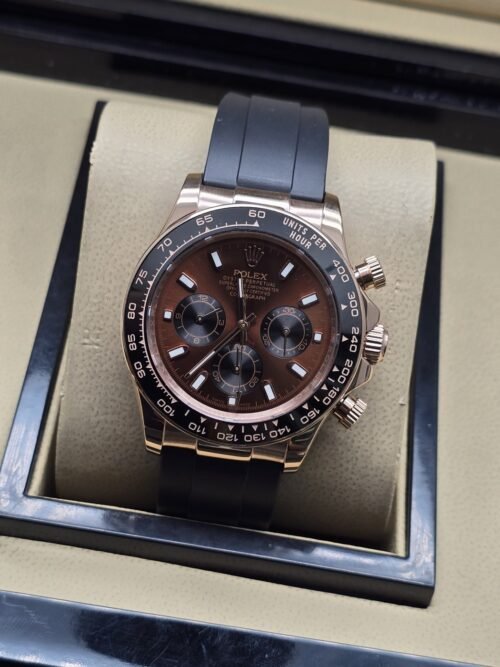 Rolex — esfera marrón con subesferas, caja rosada y correa negra