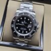 Rolex — esfera negra con bisel negro y brazalete plateado