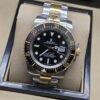 Rolex — esfera negra con bisel de números dorados y brazalete bicolor