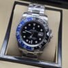 Rolex — esfera negra con bisel azul y negro, brazalete plateado