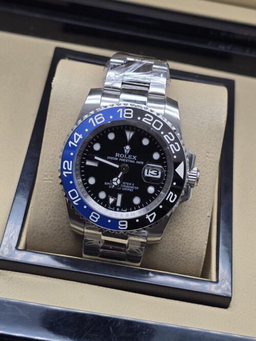 Rolex — esfera negra con bisel azul y negro, brazalete plateado