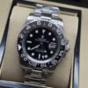 Rolex — esfera negra con bisel negro numerado y brazalete plateado