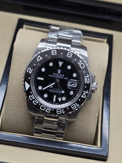 Rolex — esfera negra con bisel negro numerado y brazalete plateado