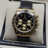 Rolex — esfera oscura con subesferas doradas y correa negra