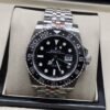 Rolex — esfera negra con bisel negro numerado y brazalete plateado