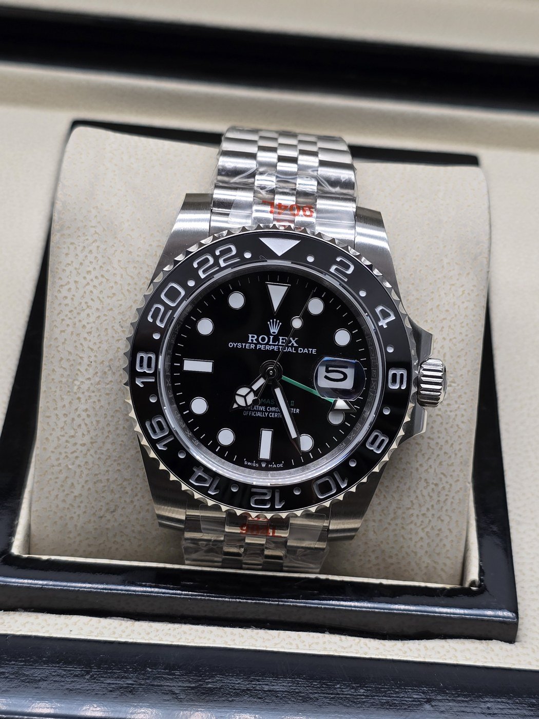 Rolex — esfera negra con bisel negro numerado y brazalete plateado