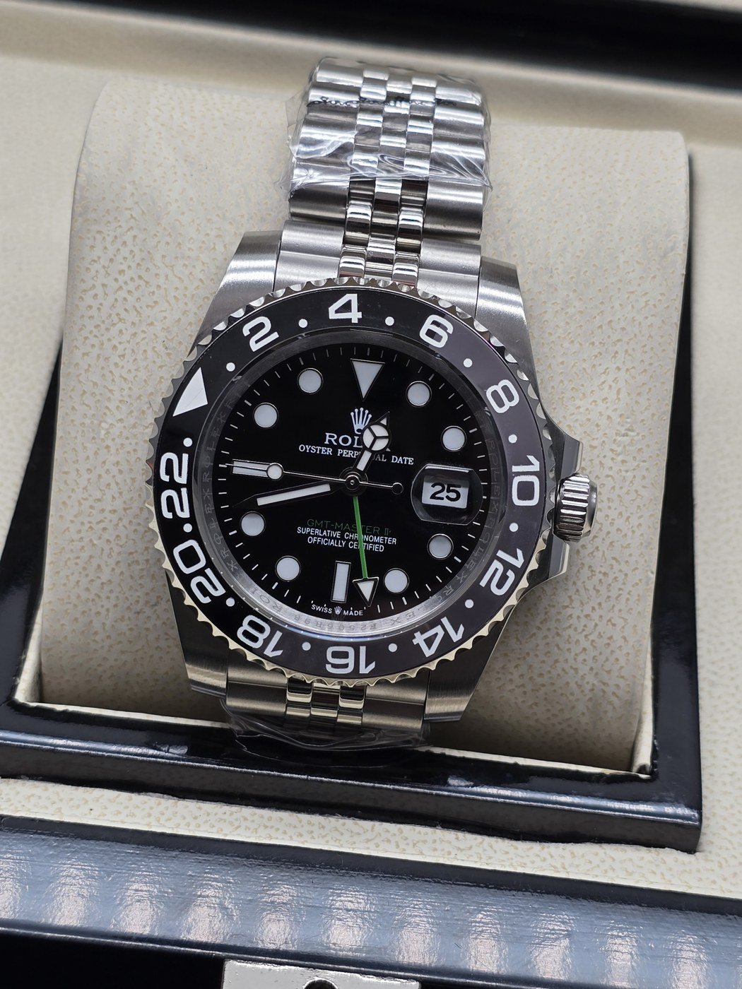 Rolex — esfera negra con bisel numerado y brazalete de eslabones plateados