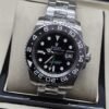Rolex — esfera oscura con bisel negro numerado y brazalete plateado