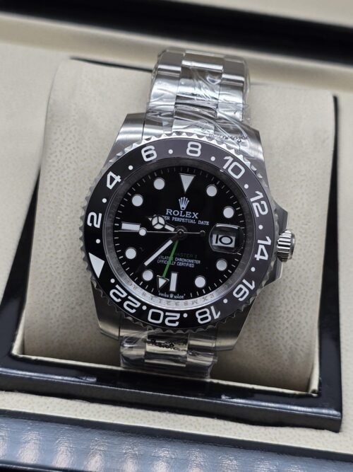 Rolex — esfera oscura con bisel negro numerado y brazalete plateado