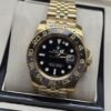 Rolex — esfera oscura con bisel numerado y brazalete dorado