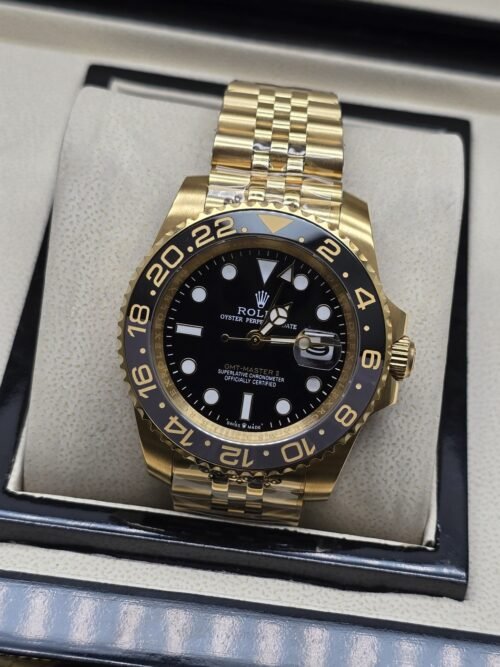 Rolex — esfera oscura con bisel numerado y brazalete dorado