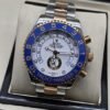 Rolex — esfera blanca con bisel azul numerado y brazalete bicolor