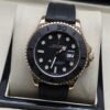 Rolex — esfera negra con bisel gris, caja rosada y correa negra