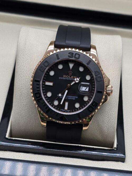 Rolex — esfera negra con bisel gris, caja rosada y correa negra