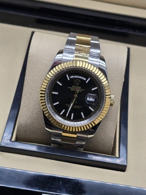 Rolex — esfera negra con bisel dorado estriado y brazalete bicolor · 41 mm