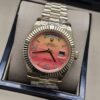 Rolex — esfera naranja degradada con bisel estriado y brazalete dorado · 41 mm