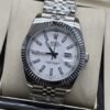 Rolex — esfera blanca con fecha y bisel estriado y brazalete plateado · 41 mm