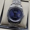 Rolex — esfera azul oscura con bisel estriado y brazalete plateado · 41 mm