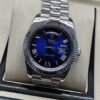 Rolex — esfera azul con números romanos y bisel estriado y brazalete plateado · 41 mm