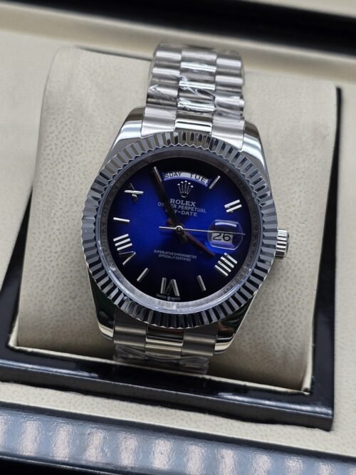 Rolex — esfera azul con números romanos y bisel estriado y brazalete plateado · 41 mm