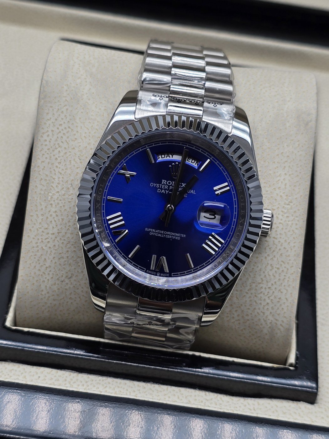 Rolex — esfera azul con índices claros y bisel estriado y brazalete plateado · 41 mm