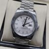 Rolex — esfera blanca con índices claros y bisel estriado y brazalete plateado · 41 mm