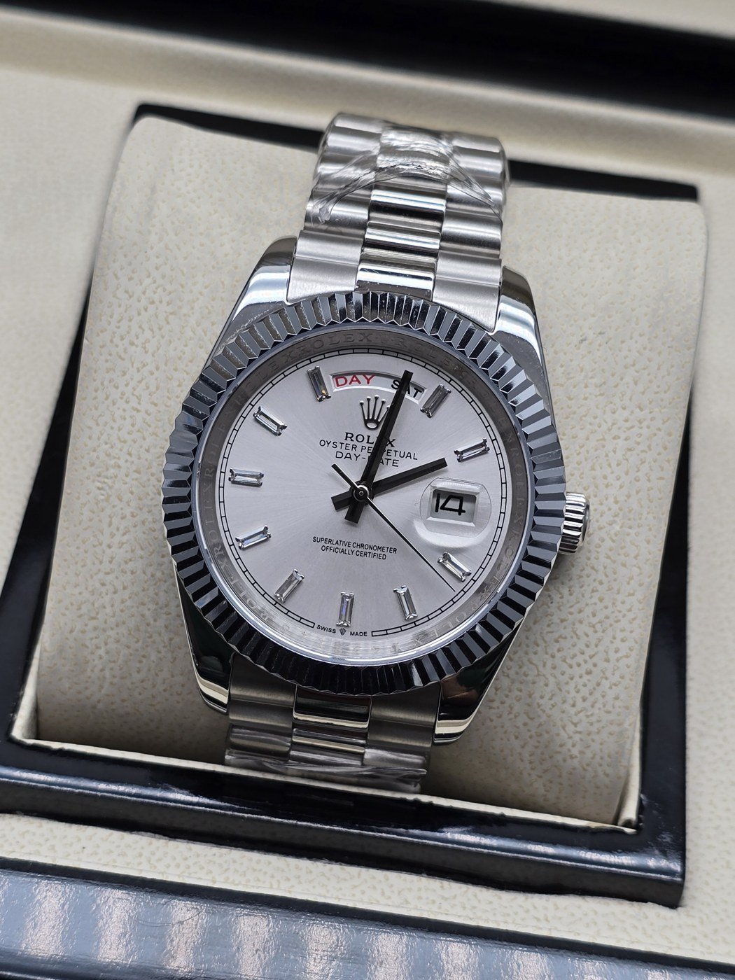 Rolex — esfera blanca con índices claros y bisel estriado y brazalete plateado · 41 mm