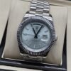 Rolex — esfera azul clara con bisel estriado y brazalete plateado · 41 mm