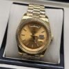 Rolex — esfera dorada anaranjada con bisel estriado y brazalete dorado · 41 mm