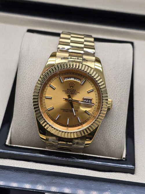 Rolex — esfera dorada anaranjada con bisel estriado y brazalete dorado · 41 mm