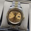 Rolex — esfera dorada con fecha y bisel estriado y brazalete bicolor · 41 mm