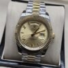 Rolex — esfera dorada clara con bisel estriado y brazalete bicolor · 41 mm