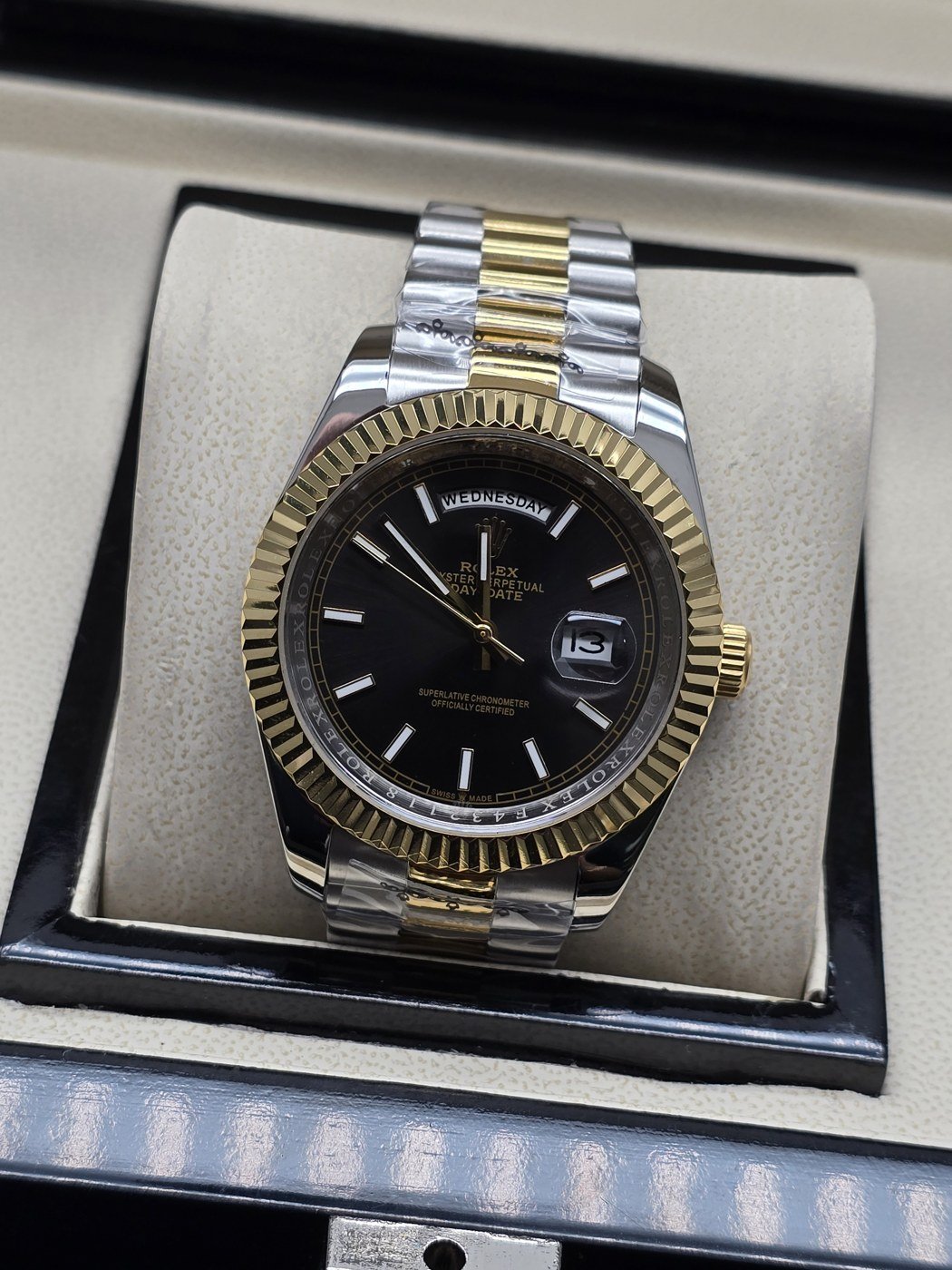 Rolex — esfera negra con índices claros y bisel dorado y brazalete bicolor · 41 mm