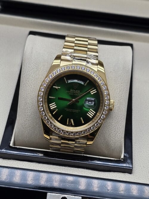 Rolex — esfera verde oscura con bisel brillante y brazalete dorado · 41 mm